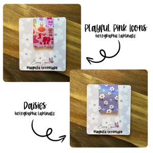 Puede incluir: Dos marcadores magn&eacute;ticos con laminado hologr&aacute;fico. El primer marcador presenta un fondo rosa con una variedad de iconos rosas y el texto "Playful Pink Icons". El segundo marcador presenta un fondo morado con un patr&oacute;n de margarita blanca y el texto "Daisies". Ambos marcadores tienen el texto "Emmy Grace Designs" y "Magnetic Bookmark".