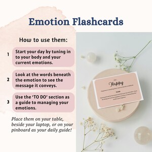 May include: Emotion Flashcards with instructions on how to use them. A card reads "Happy" with the text "Happiness is revealing what I want to cherish or celebrate." The cards are on a beige plate with decorative flowers and two white stones.