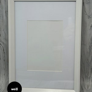May include: A white picture frame with a white mat. The frame is on a white wood background. The word "wei&szlig;" is written in black on a white circle in the lower left corner of the image.