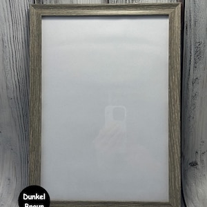 May include: A gray wood picture frame with a white mat. The frame is on a white wood background.