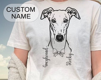 May include: White t-shirt with a black and white illustration of a Greyhound dog wearing a bow tie. The text "Greyhound" and "Rocky" are written on the shirt.