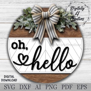 Könnte beinhalten: Ein rundes Holzschild mit einem weißen Chevron-Muster und dem Text "oh, hello" in schwarzer Schrift. Oben auf dem Schild befindet sich eine graue und weiße Schleife mit grünen Blättern.