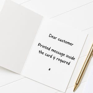 a white card with handwritten text and a pen on a white surface.