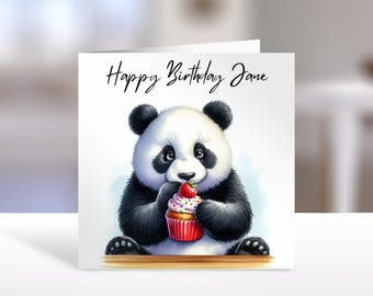 May include: A square greeting card featuring a black and white panda illustration holding a cupcake topped with a strawberry. The text Happy Birthday Jane is printed in black script at the top of the white card against a soft blue background.