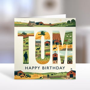 May include: A square greeting card featuring the name TOM in large block letters filled with illustrations of farm life, including tractors, livestock, barns, and fields. Below the name, the text reads HAPPY BIRTHDAY in dark blue capital letters.