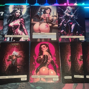 May include: Set of eight trading cards featuring illustrations of vampires. The cards are black with red accents and feature various female vampires in different poses. The cards are all the same size and have the same design.