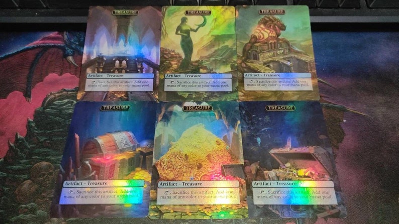 May include: Six holographic Magic: The Gathering cards featuring the "Treasure" artifact. Each card has a different image of a treasure chest, a pile of gold coins, or a building with a treasure inside. The text on the cards reads "Artifact - Treasure" and "Sacrifice this artifact: Add one mana of any colour to your mana pool."