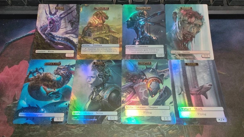 May include: A set of ten Magic: The Gathering cards featuring various creatures and artifacts. The cards are holographic and have a rainbow sheen. The cards include a blue and white creature called "Morm", a gold artifact called "Treasure", a blue and white creature called "Construct", a red and white creature called "Zombie", a blue and white creature called "Magma", a blue and white creature called "Servo", a blue and white creature called "Thopter", and a blue and white creature called "Shark".