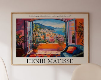 May include: A colourful painting of a view from a window, with a blue armchair in the foreground. The painting is framed and has the text "Henri Matisse" below it. The painting is hanging on a white wall in a room with a wooden table and two white chairs.