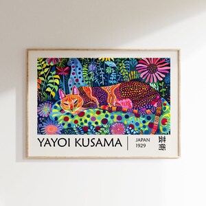 May include: A colorful poster featuring a cat lying on a bed of flowers. The cat is covered in polka dots and the flowers are a mix of pink, purple, blue, and yellow. The poster is by Yayoi Kusama, a Japanese artist born in 1929. The text on the poster reads "Yayoi Kusama" and "Japan 1929" in black text.