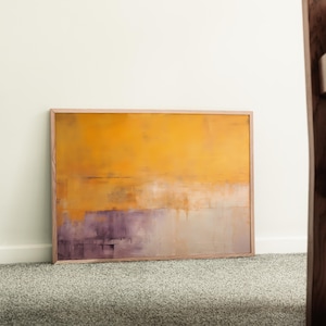 May include: Abstract art print in a wooden frame. The artwork features a blend of warm colours, with a dominant yellow-orange hue at the top transitioning to purple and beige at the bottom. The painting has a textured appearance.