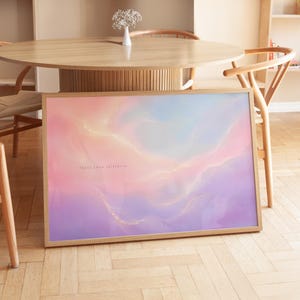 Könnte beinhalten: Ein rechteckiges gerahmtes Wandbild mit einer abstrakten Mischung aus sanftem Rosa, Lavendel und Hellblau mit subtilen goldfarbenen Adern. Der Text "float into stillness" ist in kleinen, dunklen Buchstaben auf der linken Seite gedruckt.