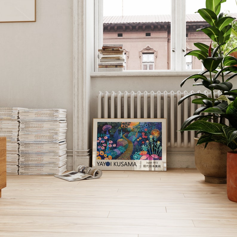 May include: A framed print of a painting by Yayoi Kusama. The painting depicts a whimsical garden with flowers, mushrooms, and a winding path. The text "Yayoi Kusama" and "Japan 1972" is printed at the bottom of the print.