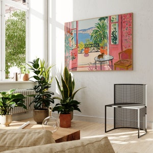 Puede incluir: Una pintura de una habitaci&oacute;n rosa y blanca con una ventana que da a un mar azul. La habitaci&oacute;n tiene una silla, una mesa y una planta en maceta. Un gato est&aacute; sentado en la mesa.
