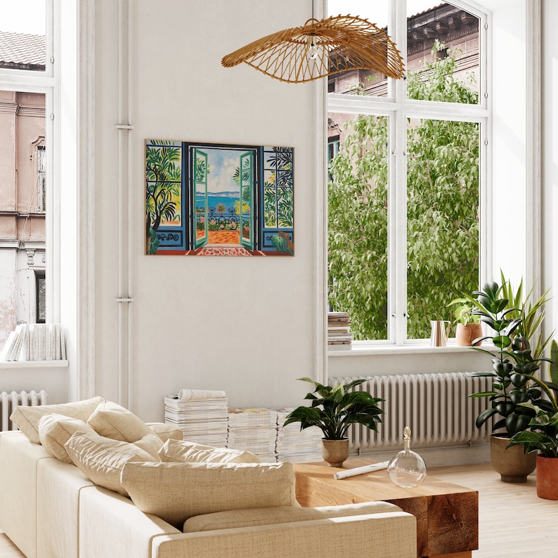Puede incluir: Una pintura de una puerta abierta con vista a un balc&oacute;n que da a un oc&eacute;ano azul. El balc&oacute;n tiene una barandilla de hierro forjado y algunas plantas en macetas. La pintura est&aacute; enmarcada y colgada en una pared blanca en un sal&oacute;n.