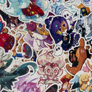 May include: A collection of colorful, holographic stickers featuring various cartoon characters. The stickers showcase a variety of designs, including characters with vibrant hair, costumes, and accessories. The stickers have a glossy finish and are suitable for decorating various items.