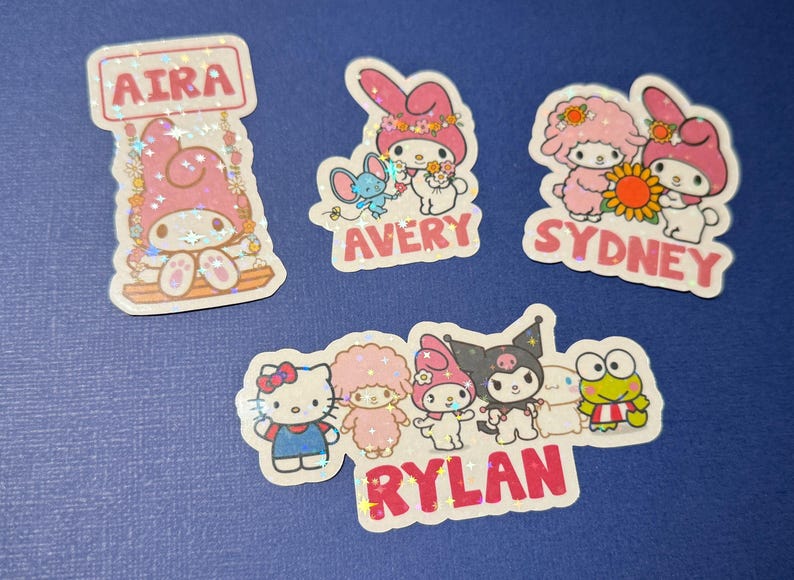 May include: Five colorful stickers featuring the characters from the popular children's cartoon, Little Twin Stars. Each sticker has a different name, including Aira, Avery, Sydney, Rylan, and a sticker with a group of characters. The stickers are decorated with glitter and have a whimsical design.