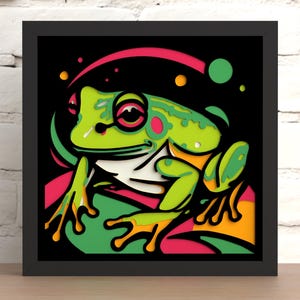 Puede incluir: Una rana verde con manchas rosadas y blancas se sienta sobre un fondo colorido y en capas. La rana tiene un ojo grande y redondo y una amplia sonrisa con dientes. El fondo es una mezcla de rosa, naranja, amarillo y verde.