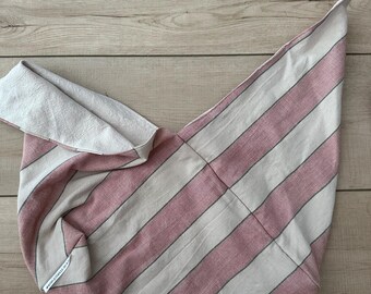 May include: A striped tote bag in pink and white with a gray accent stripe. The bag is folded and has a triangular shape. The bag is made of fabric and has a tag that reads "warmpalette.ma".