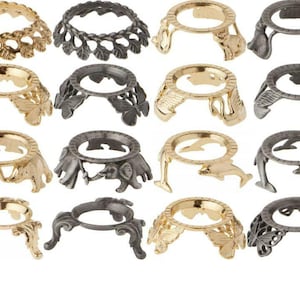 May include: Set of 12 decorative metal orb stands in gold and silver tones. Each stand features a different design, including butterflies, swans, elephants, and dolphins.