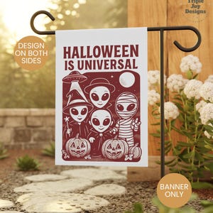 May include: A Halloween garden flag with the text "HALLOWEEN IS UNIVERSAL" and a maroon graphic of aliens, pumpkins, and a mummy. The flag is displayed on a black metal stand in a garden setting.