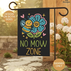 May include: A black garden flag with a cartoon bee on a flower. The text "No Mow Zone" is written in white letters.