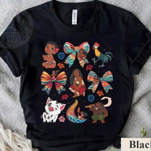May include: Black t-shirt featuring colorful illustrations of characters and bows. The design includes a baby, a rooster, a pig, and a man with a staff. The word "Black" is printed at the bottom right.