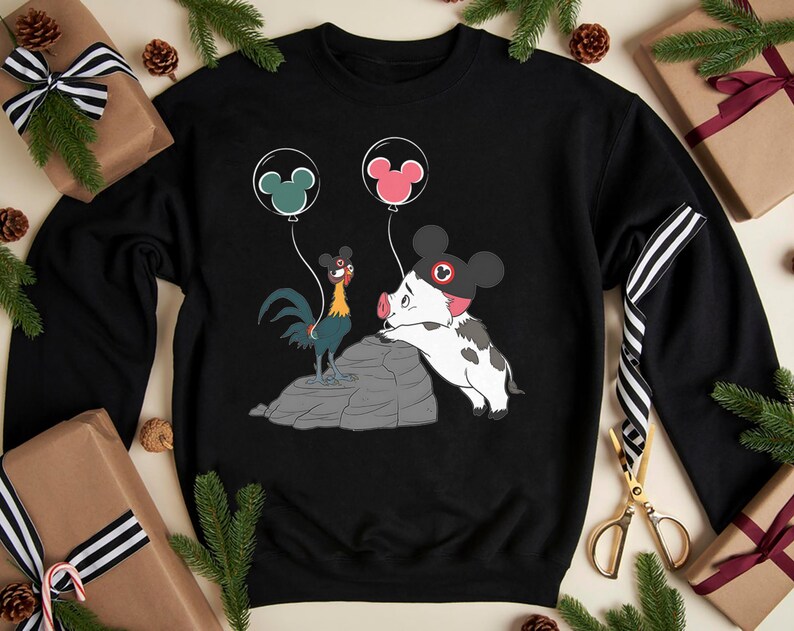 May include: Black sweatshirt with a cartoon rooster and pig design, holding Mickey Mouse ear balloons. The rooster is blue, yellow, and red, and the pig is white and black. Balloons are green and pink.