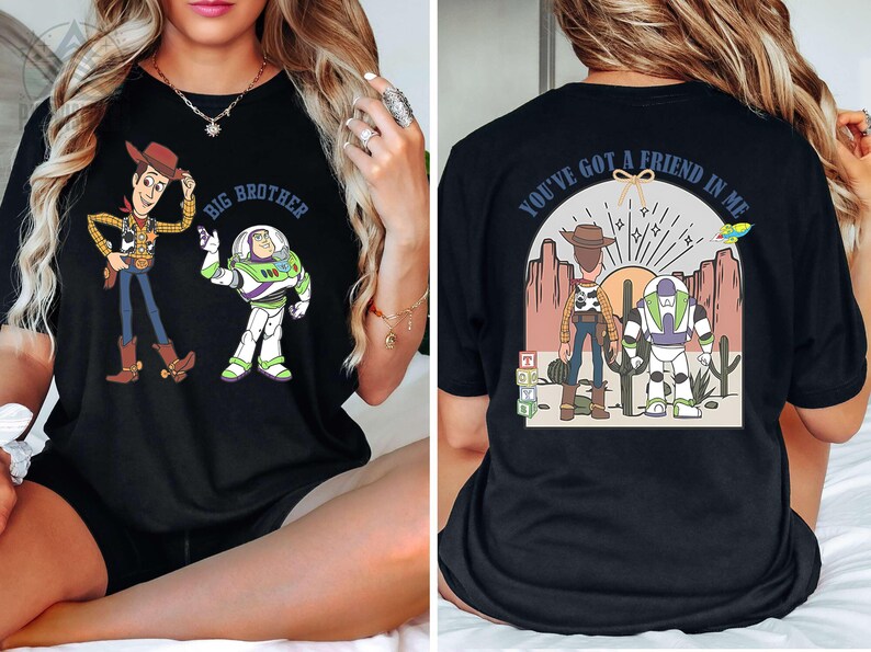 May include: Black t-shirt featuring Woody and Buzz Lightyear from Toy Story. The front of the shirt says "Big Brother" above the characters. The back of the shirt says "You've got a friend in me" with the characters and a desert scene.