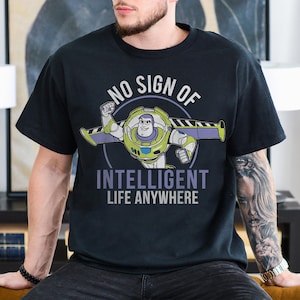 Op de afbeelding: Zwart T-shirt met een afbeelding van Buzz Lightyear uit Toy Story. De tekst "No sign of intelligent life anywhere" staat op het shirt gedrukt.