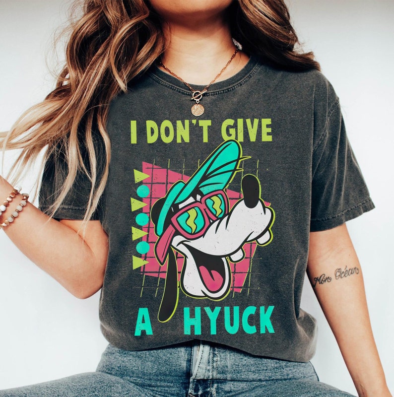 May include: A black t-shirt with a retro-style graphic of Goofy wearing sunglasses and a hat. The text "I don't give a hyuck" is printed on the shirt.