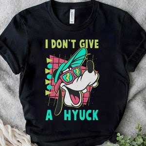 May include: Black t-shirt with a cartoon dog wearing sunglasses and a hat. The text "I don't give a hyuck" is printed on the shirt.