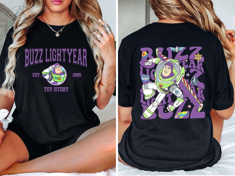May include: Black t-shirt featuring a graphic of Buzz Lightyear from Toy Story. The front design includes the text "Buzz Lightyear" in purple, with "Est. 1995" and "Toy Story" below. The back has a larger Buzz Lightyear graphic and text.