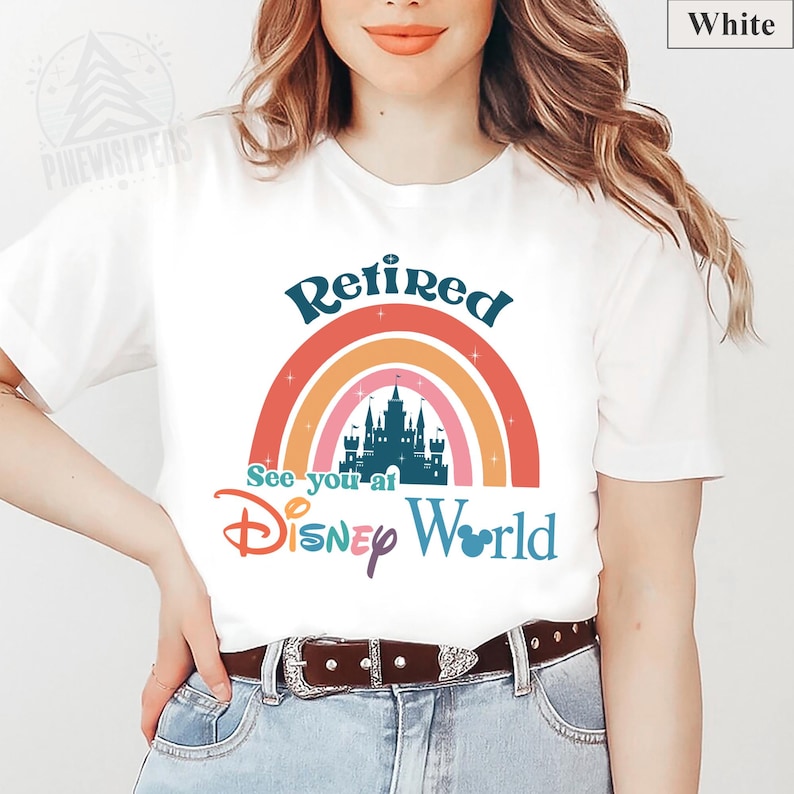 K&ouml;nnte beinhalten: Wei&szlig;es T-Shirt mit einem Regenbogen-Design und dem Text "Retired See you at Disney World".