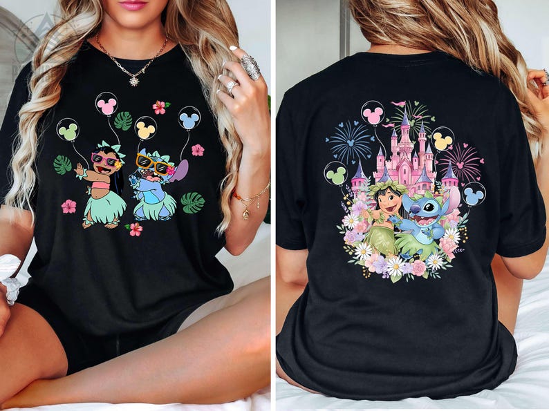 May include: Black t-shirt featuring a colorful graphic of two cartoon characters holding Mickey Mouse balloons. The front design shows the characters in sunglasses and grass skirts. The back design shows a castle and fireworks.