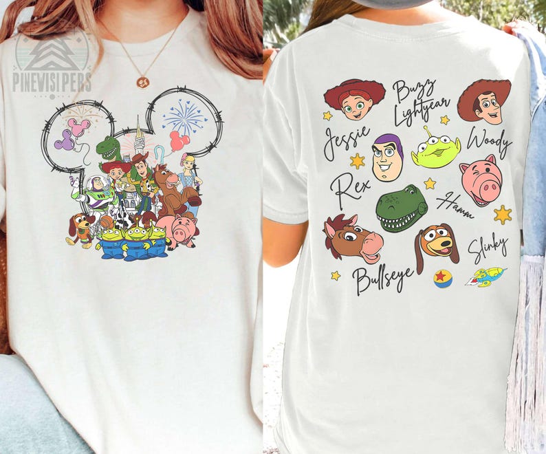 Pu&ograve; includere: T-shirt bianca con una grafica colorata dei personaggi di Toy Story sul davanti, all'interno di un contorno della testa di Topolino. Il retro mostra ritratti di personaggi e nomi, come Woody e Buzz.
