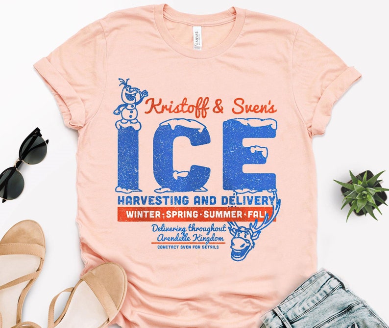 May include: A pink t-shirt with a vintage-style graphic featuring Kristoff and Sven's Ice Harvesting and Delivery service. The graphic includes a cartoon image of Olaf and Sven, and the text "Kristoff & Sven's ICE HARVESTING AND DELIVERY WINTER; SPRING SUMMER FALL Delivering throughout Arendelle Kingdom CONCTACT SVEN FOR DETAILS."