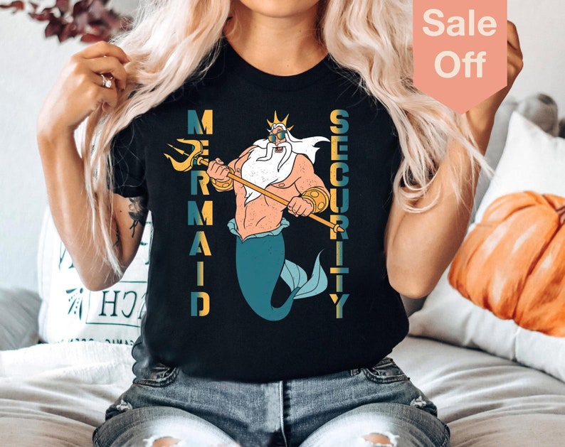 May include: A black t-shirt with a graphic of King Triton from The Little Mermaid. The text "Mermaid Security" is printed vertically on the shirt.