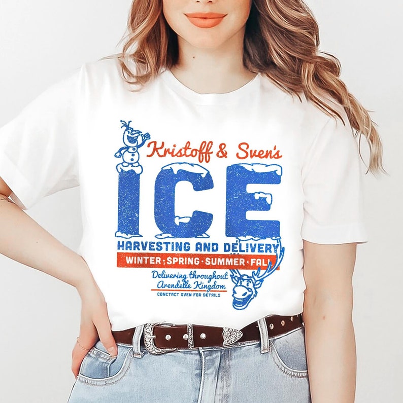 May include: White t-shirt with a blue and red graphic design featuring the text "Kristoff & Sven's ICE HARVESTING AND DELIVERY WINTER SPRING SUMMER FALL Delivering throughout Arendelle Kingdom CONTACT SVEN FOR DETAILS" and illustrations of Olaf and Sven.