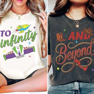 Puede incluir: Dos camisetas con diseños gráficos. Una es de color crema con el texto "TO infinity" y un cohete de dibujos animados. La otra es gris antracita con "AND Beyond" e ilustraciones temáticas de vaqueros.