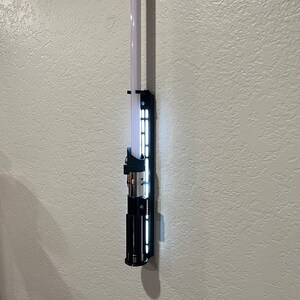 Lightsaber displayed on white display.