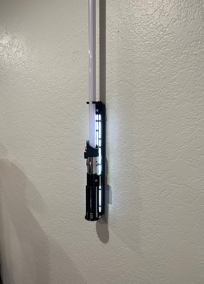 Lightsaber displayed on white display.