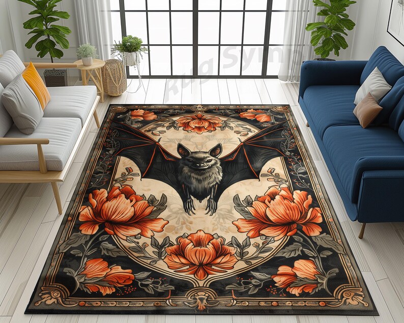 May include: A black and white rug with a floral design and a bat in the centre. The bat is black with orange eyes and is surrounded by orange flowers. The rug has a black border with a gold trim.