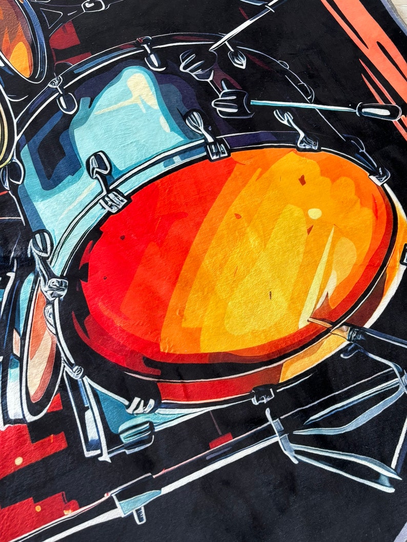 May include: A vibrant, abstract illustration of a drum set. The image features a large, red and orange drum with blue and black accents, and drumsticks. The artwork has a bold, graphic style, perfect for music lovers.