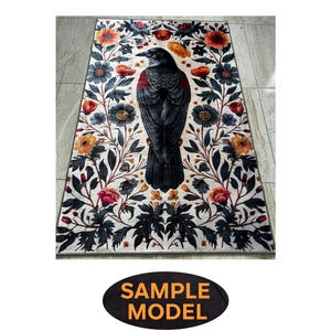 May include: A white rug with a black crow and floral design. The crow is in the center of the rug and is surrounded by flowers in shades of red, yellow, and orange.