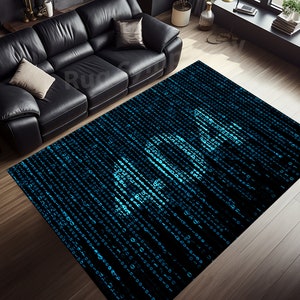 Puede incluir: Una alfombra rectangular con un diseño tipo matriz en tonos azules y negros. La alfombra presenta un patrón de líneas verticales de código binario, con la palabra "CODE" sutilmente integrada en el diseño. La alfombra está colocada sobre un suelo de madera.