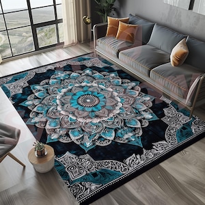 Op de afbeelding: Een blauw en zilveren mandala-kleed met een bloemenpatroon op een zwarte achtergrond. Het kleed ligt op een houten vloer in een woonkamer.