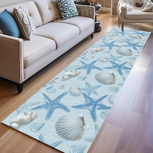 Può includere: Tappeto rettangolare con sfondo azzurro, decorato con stelle marine blu e conchiglie bianche. Il design evoca una scena di spiaggia, con una trama ondulata. Adatto per un corridoio.