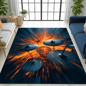 May include: A rectangular area rug featuring a dynamic drum set design. The rug showcases a central drum set with cymbals, surrounded by an explosion of orange and blue hues. The rug is placed on a light-colored wooden floor, with blue sofas and a window in the background.