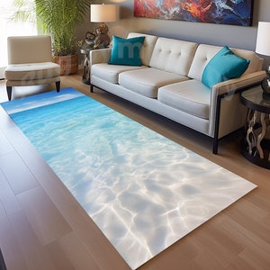 May include: A light blue and white area rug with a design that looks like the bottom of a swimming pool. The rug is laid out on a hardwood floor in a living room setting.